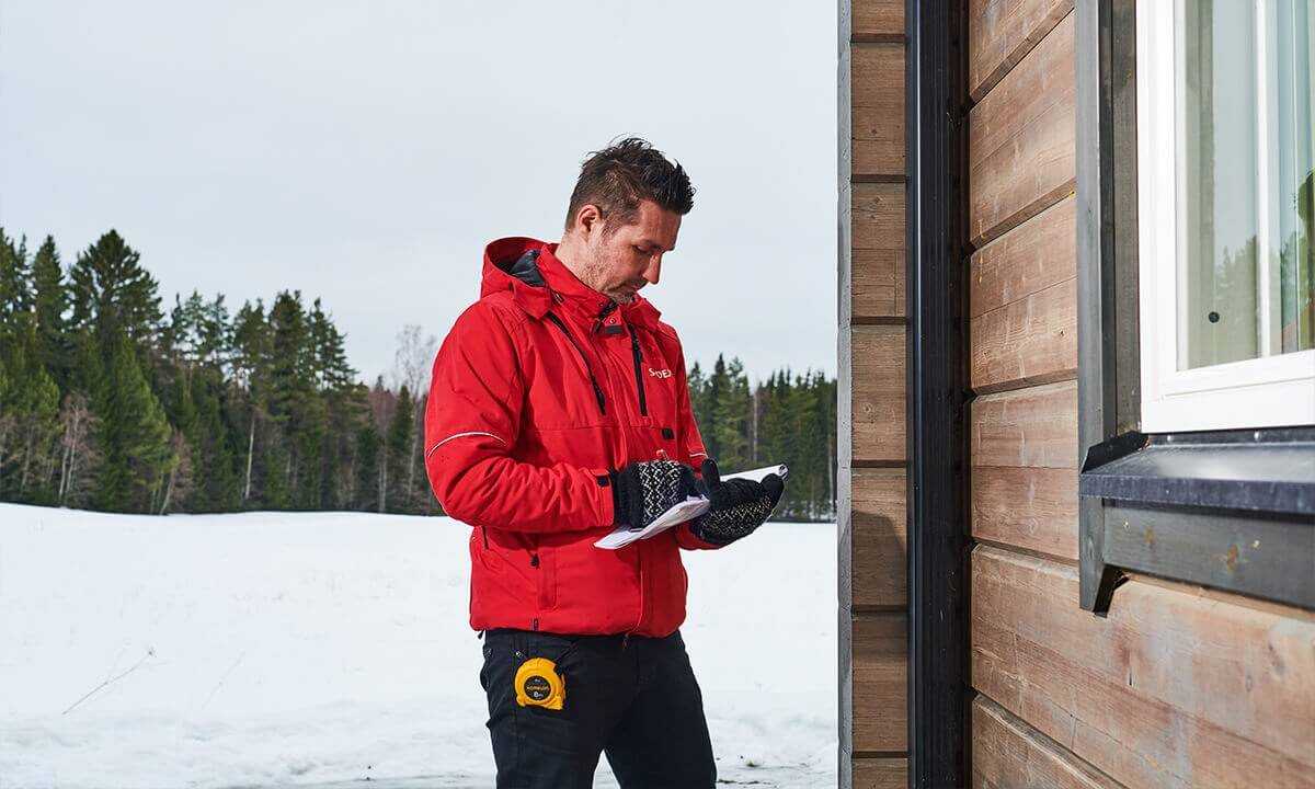 Sadexin asiantuntija tekemässä rännien ja kattoturvan kartoitusta kohteessa.